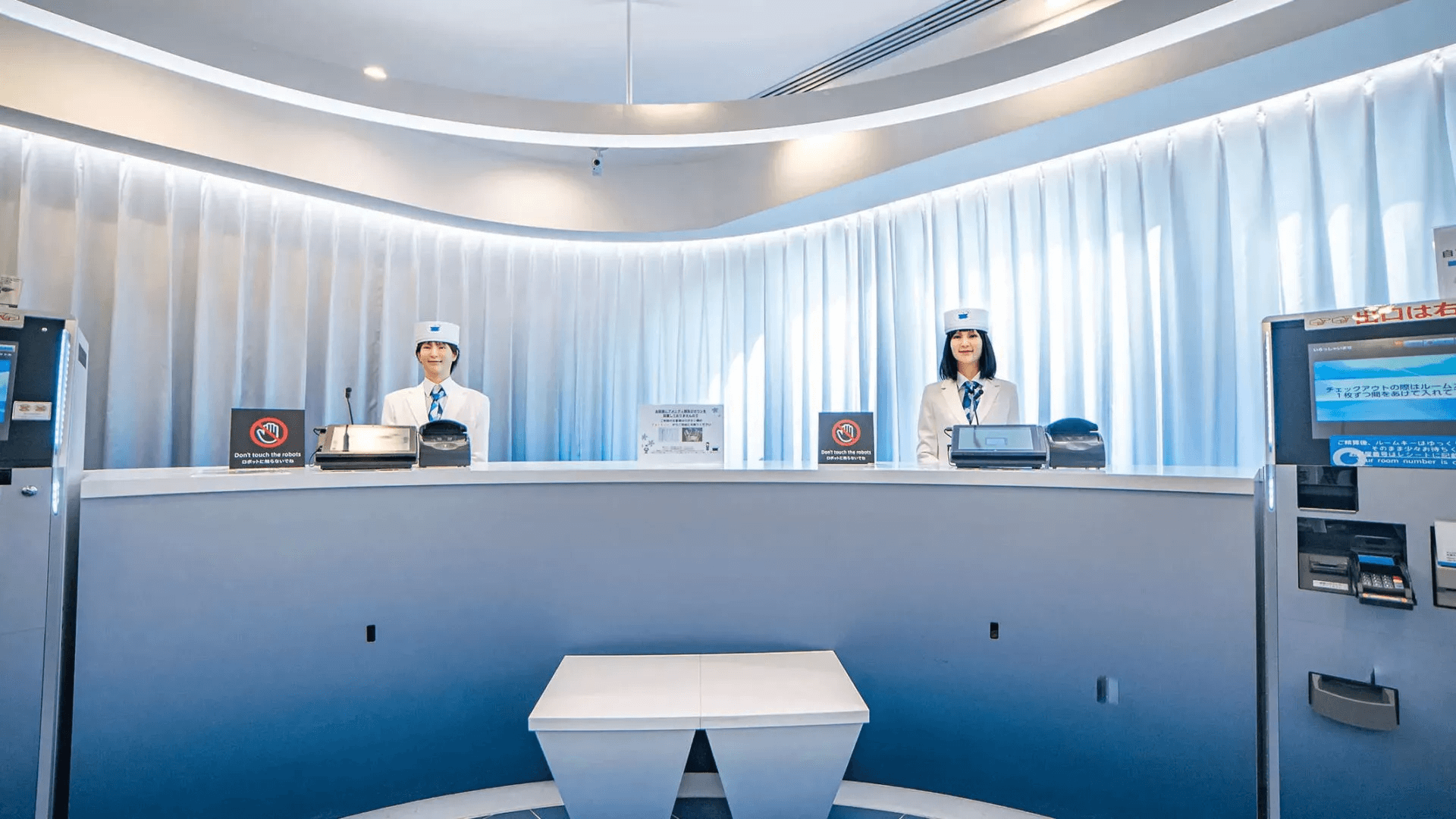 Automated hotel front desk with self-service check-in kiosks and minimal staff presence